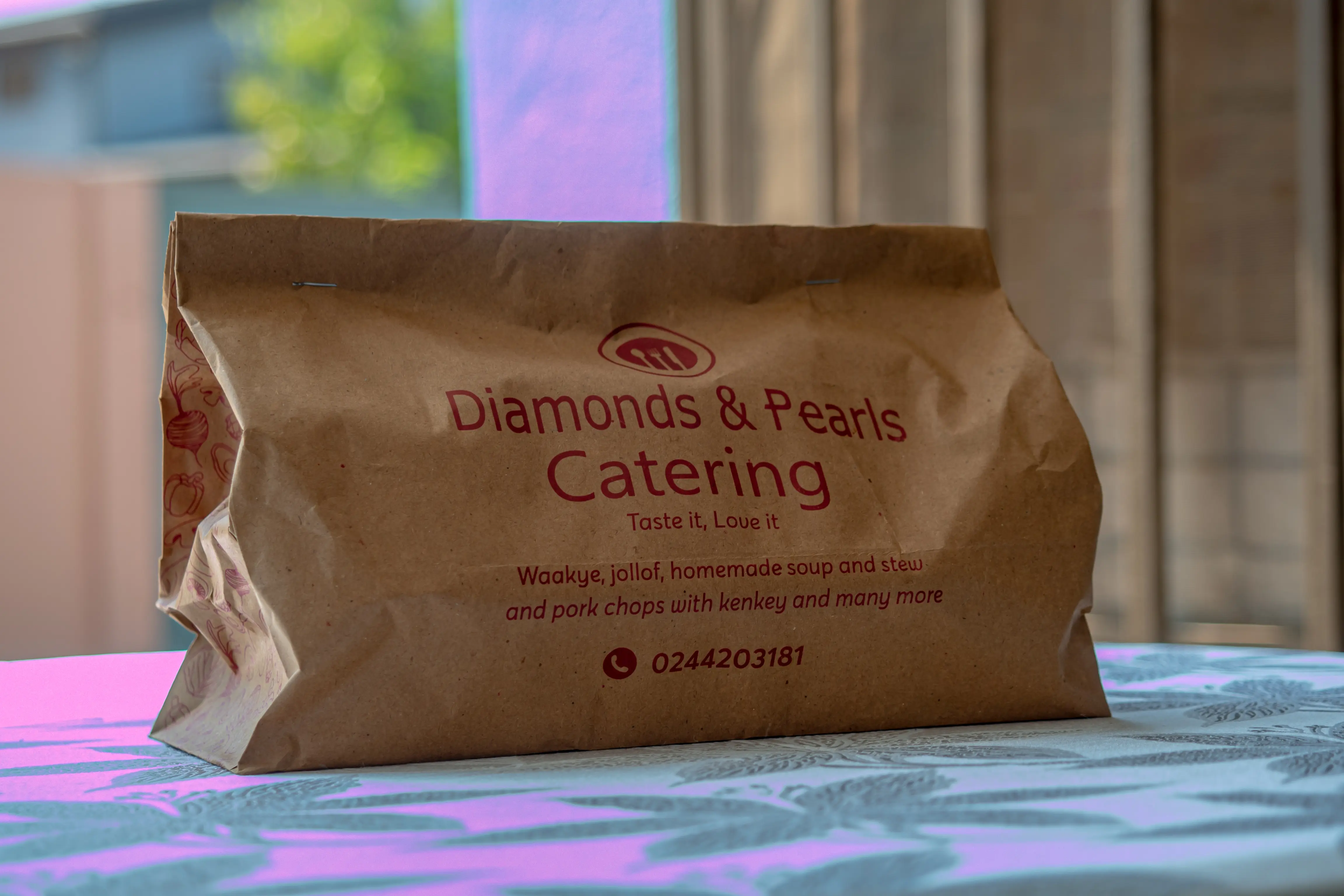 Diamonds & Pearls Catering branded paper bag — professional food packaging Accra